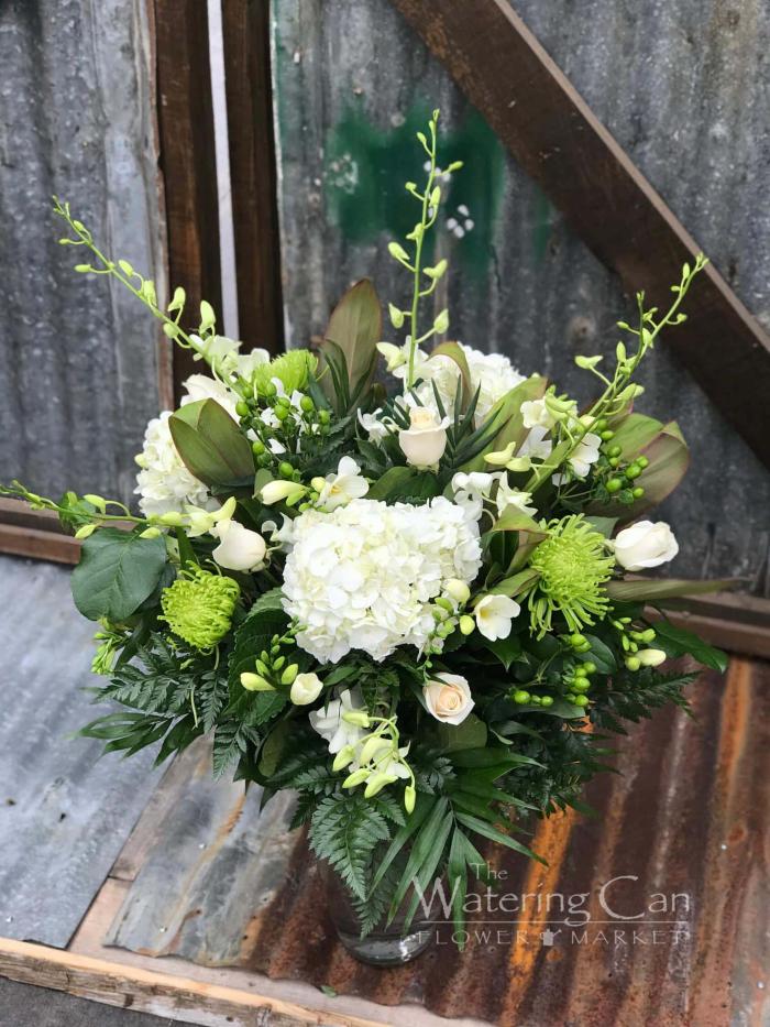 The Watering Can | A large white and green bouquet in a clear glass vase.