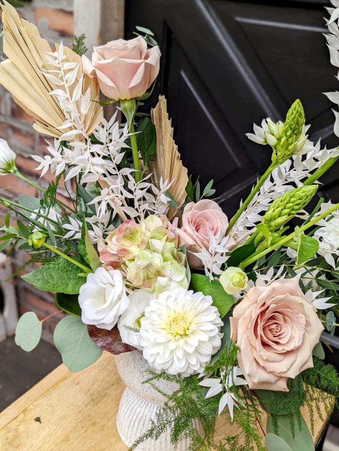 The Watering Can | Quicksand roses, white dahlias, and star of Bethlehem at the forefront of a graceful blush and white European style floral arrangement.