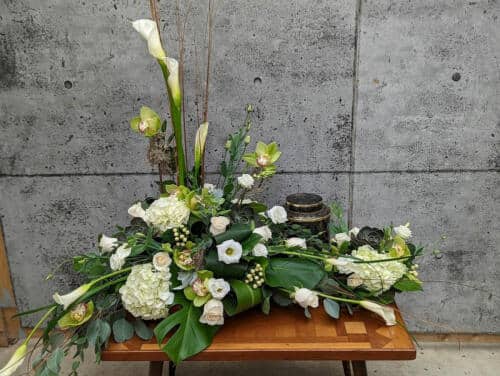The Watering Can | A Stunning white and creamtion arrangement freaturing calla lilies, hydrangea, and orchids.