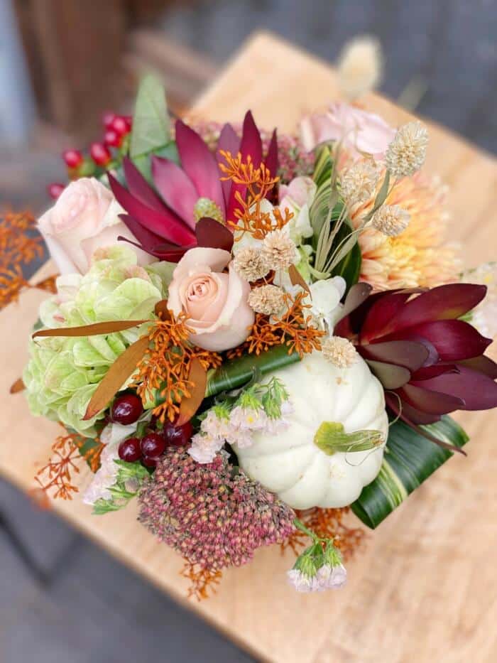 The Watering Can | A light and gentle fall themed European arrangement in burgundy, white, rust, and blush pink.
