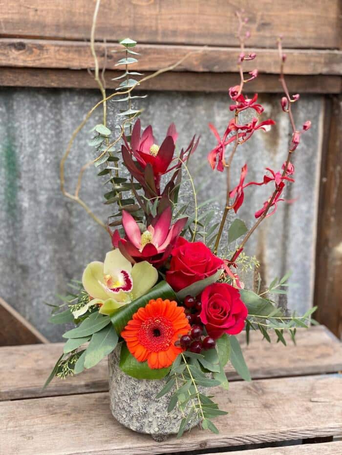 The Watering Can | A tall red european style arrangement in a textured green cermaic container.
