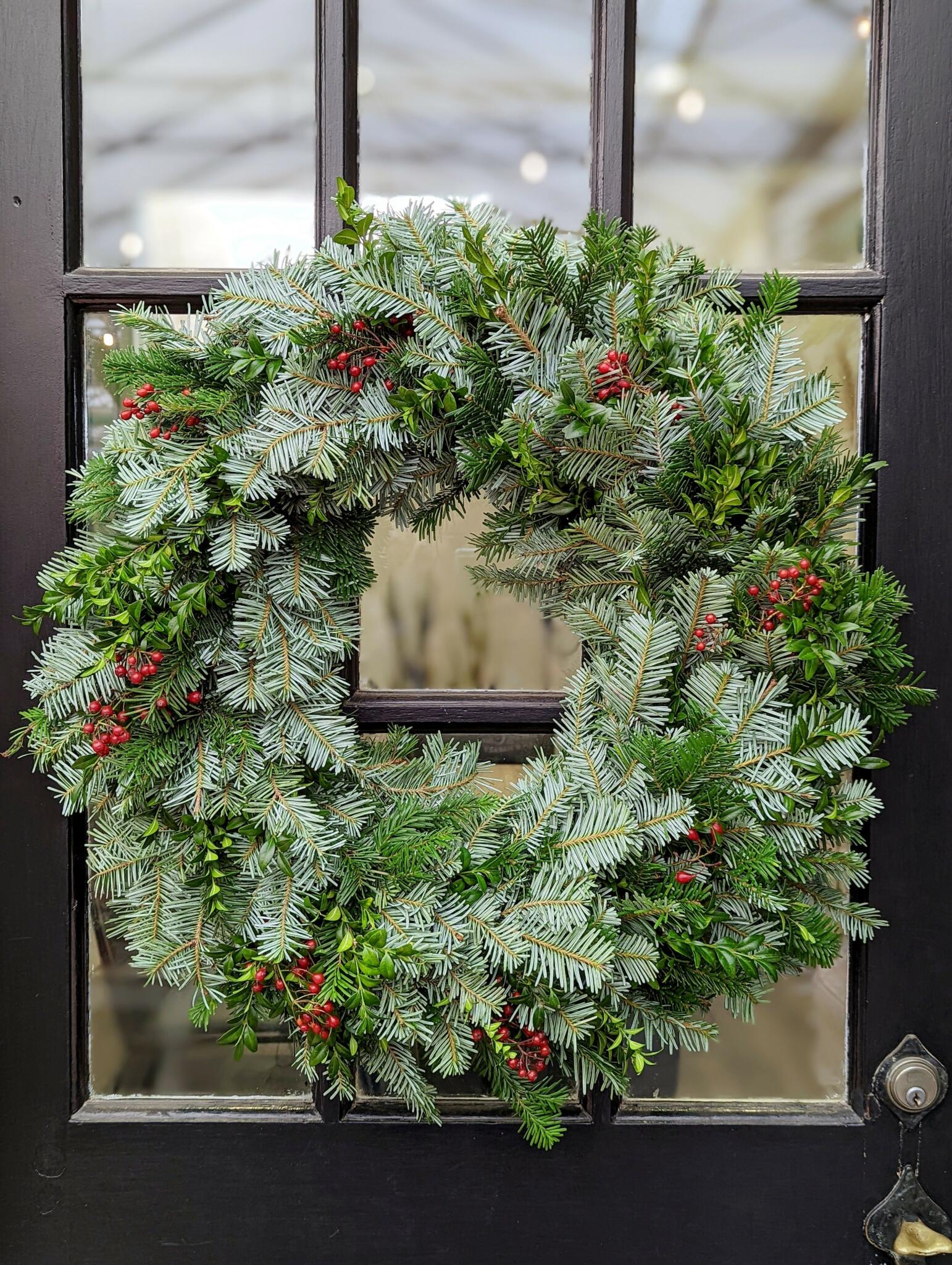 The Watering Can | A wreath made of evergreens and rosehips.